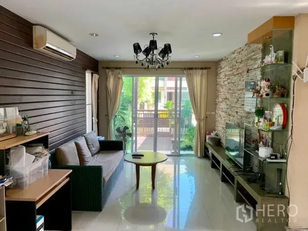 บ้าน ให้เช่าในPrawet, Bangkok - ห้องนั่งเล่นมีประตูกระจกบานเลื่อนไปยังระเบียง และผนังตกแต่งหิน
