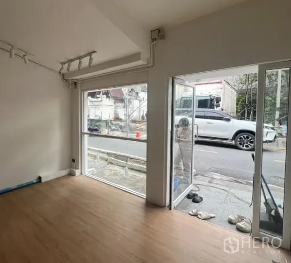 Retail Space for rent in Watthana, Bangkok - Corner of the unit showing floor-to-ceiling glass windows and a sliding glass door opening directly to the street.
