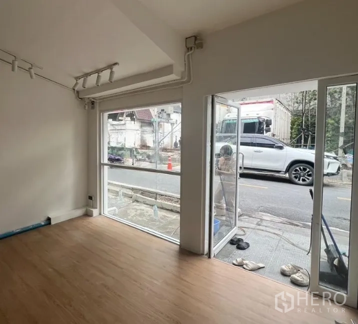 Retail Space for rent in Watthana, Bangkok - Corner of the unit showing floor-to-ceiling glass windows and a sliding glass door opening directly to the street.