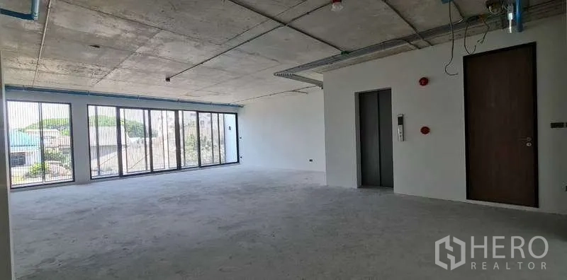 带办公室的家 出售在Suan Luang, Bangkok - 毛坯办公层另一角度，电梯核心与落地玻璃