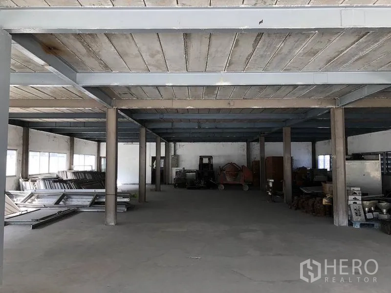 Factory for rent in Bang Phli, Samut Prakan - Ground-floor workshop and storage zone with concrete columns and industrial equipment.