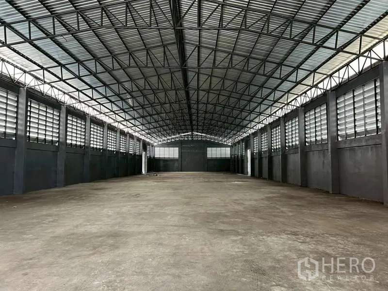 Warehouse for rent in Chachoengsao - Symmetrical view down the clear‑span warehouse hall beneath a gabled steel roof.