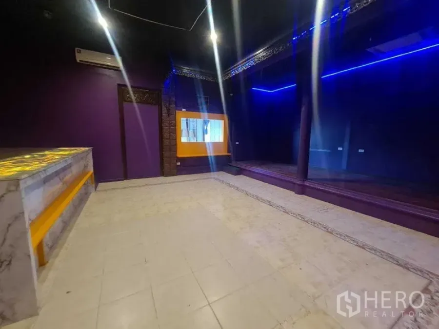零售空间 出租在Watthana, Bangkok - 零售房间带镜面般的深色墙、平台舞台及黄色点缀窗户。
