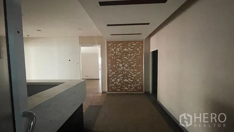 Office Space for rent or sale - Entrance foyer with carved pattern wall panel, marble desk, and recessed ceiling lighting.