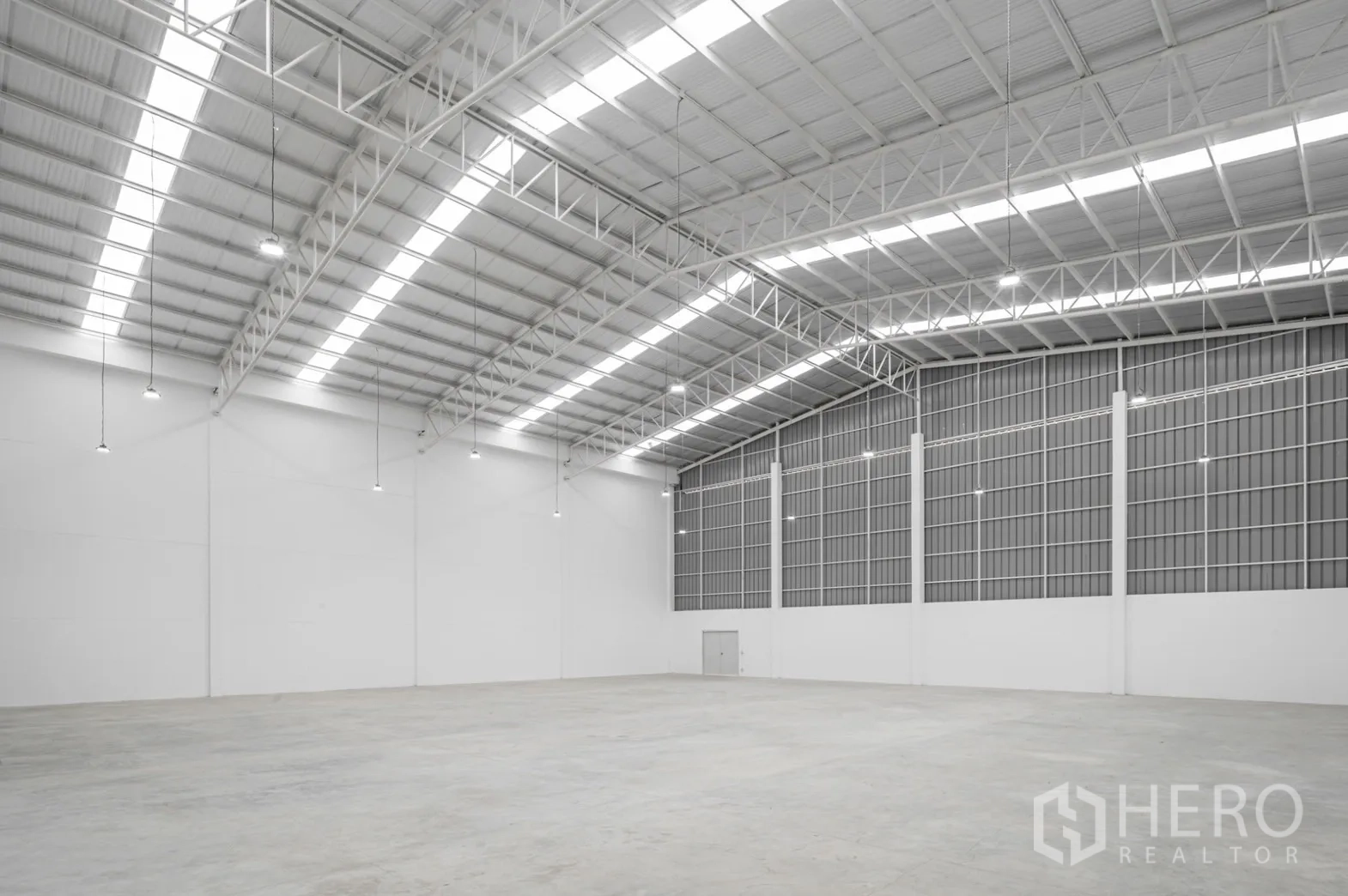 Factory for rent in Pathum Thani - Angled view of a clear-span warehouse with polished concrete floor.