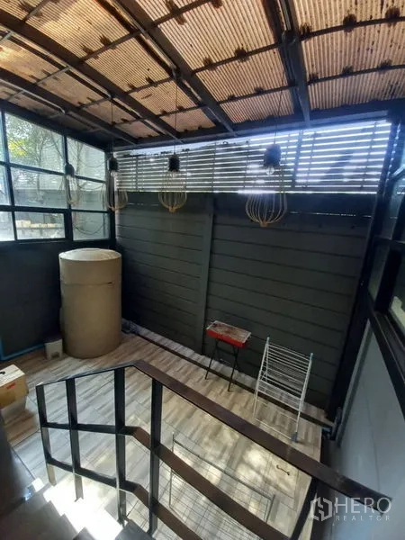 Townhouse for rent in Suan Luang, Bangkok - Covered utility terrace with industrial pendant lights, slatted windows and stair landing.