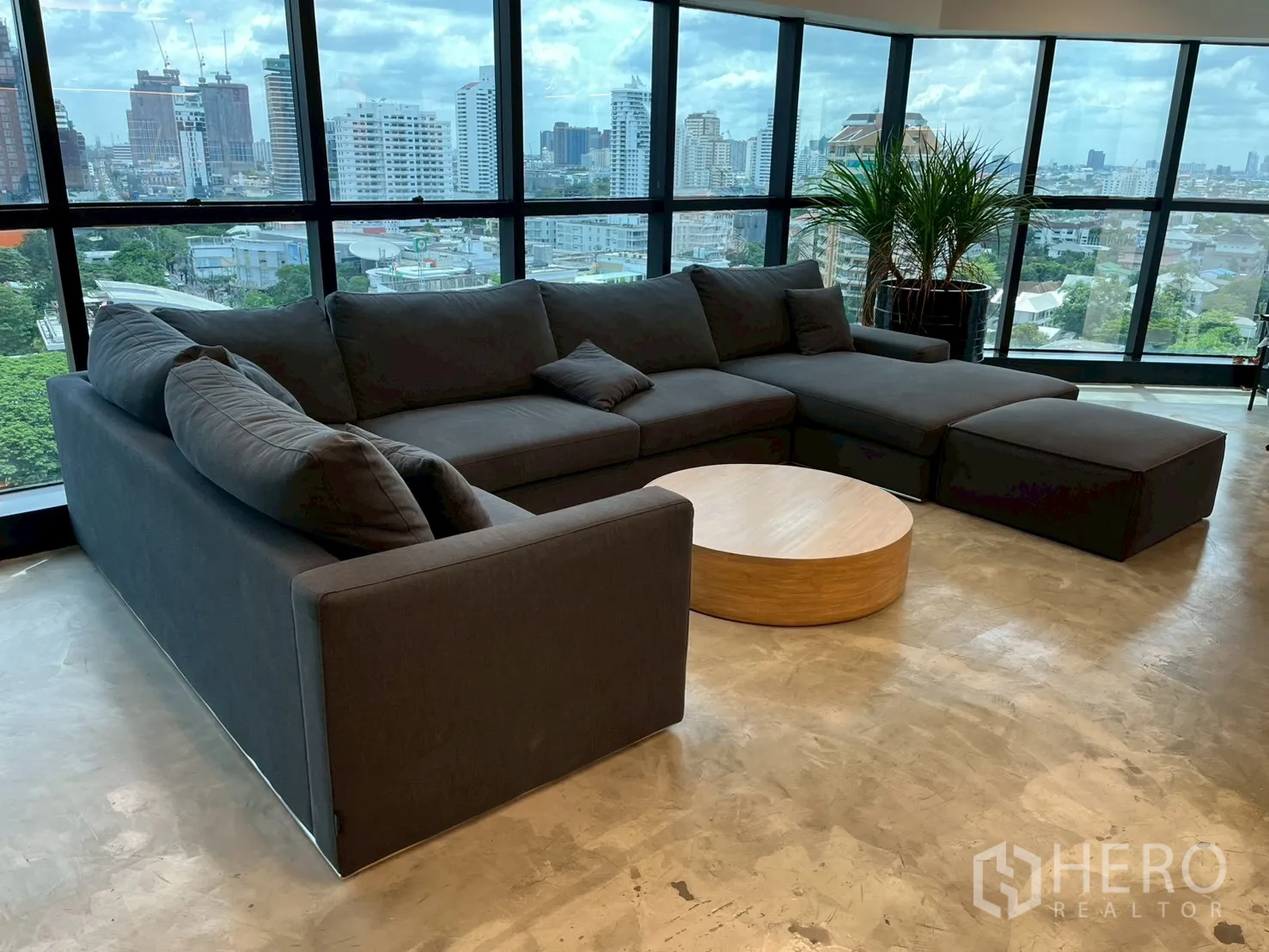 ออฟฟิศ for rent in Watthana, Bangkok - มุมเลานจ์พร้อมโซฟาตัวแอล โต๊ะกาแฟกลม ต้นไม้ และกระจกมุมกว้าง
