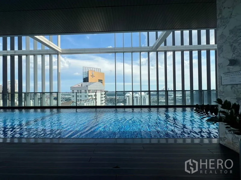 Condominium for sale - Indoor sky pool with skyline panorama framed by tall vertical slats.