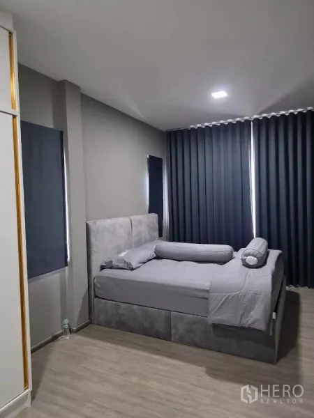 บ้าน ให้เช่าในBang Phli, Samut Prakan - ห้องนอนอบอุ่น เตียงบุผ้า ผ้าม่านทึบ และพื้นลายไม้.