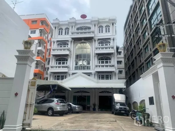 办公空间 出租在Khlong San, Bangkok - 办公室正立面，带门廊入口与停车区，周边为中高层建筑。