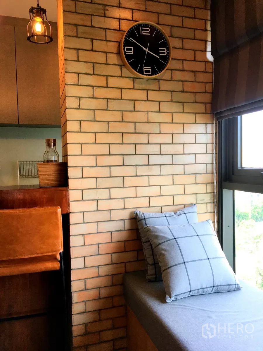 Condominium for rent in Khlong Toei, Bangkok - Brick column with wall clock and cushioned window seat overlooking city greenery