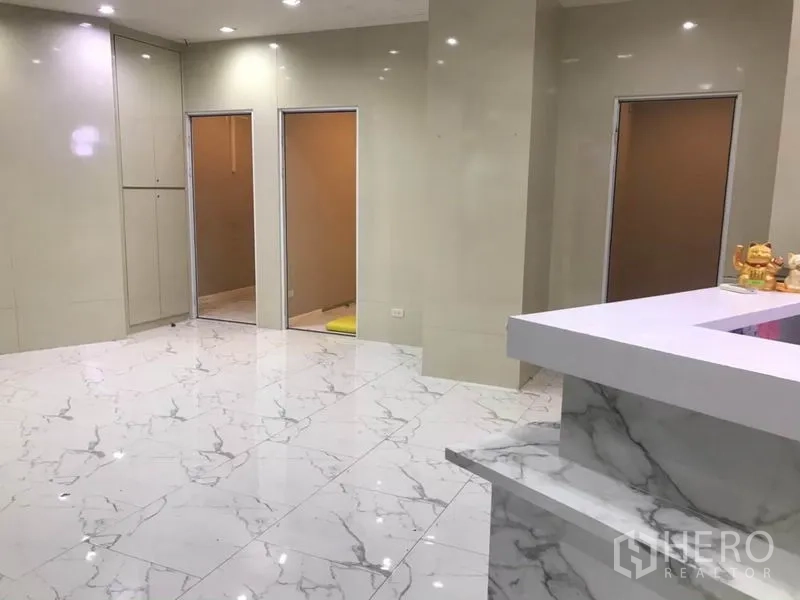 零售空间 出租在Watthana, Bangkok - 明亮商铺内景，仿大理石地砖、筒灯与分隔房间。