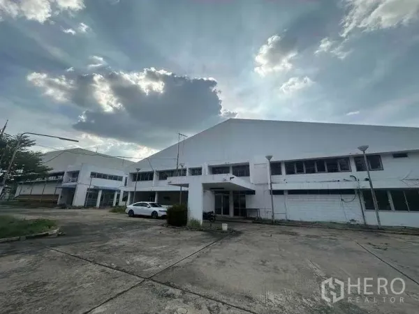 Factory for rent in Khlong Luang, Pathum Thani - Front façade of the factory complex with a wide concrete forecourt