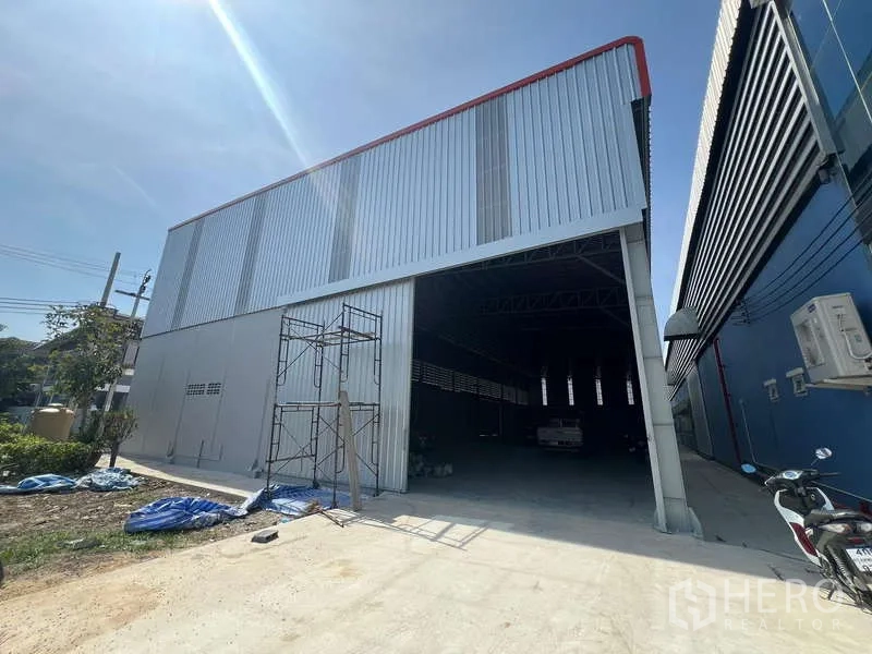 货栈 出租在Prawet, Bangkok - 宽阔入口，超高门洞与位于工业建筑之间的车道。