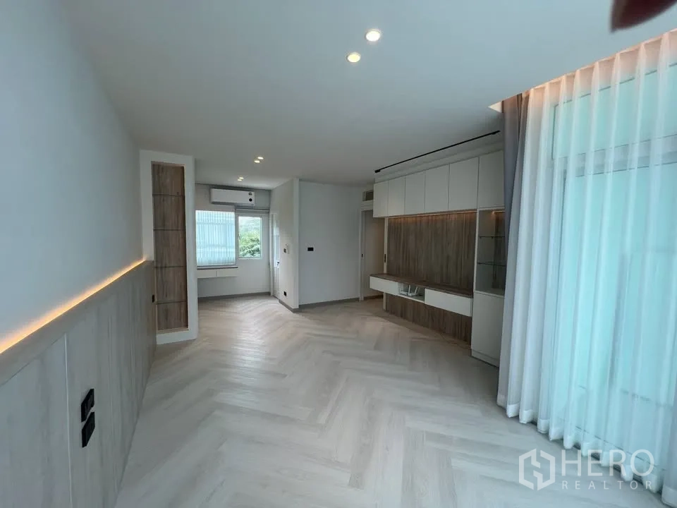 联排别墅 for rent in Prawet, Bangkok - 开放起居区，带电视柜、窗户和纱帘。