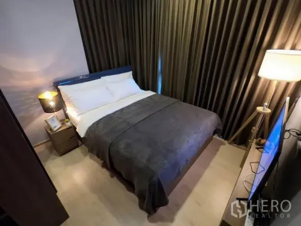 公寓 出租或出售在Watthana, Bangkok - 次卧配双人床、遮光窗帘与床头灯。