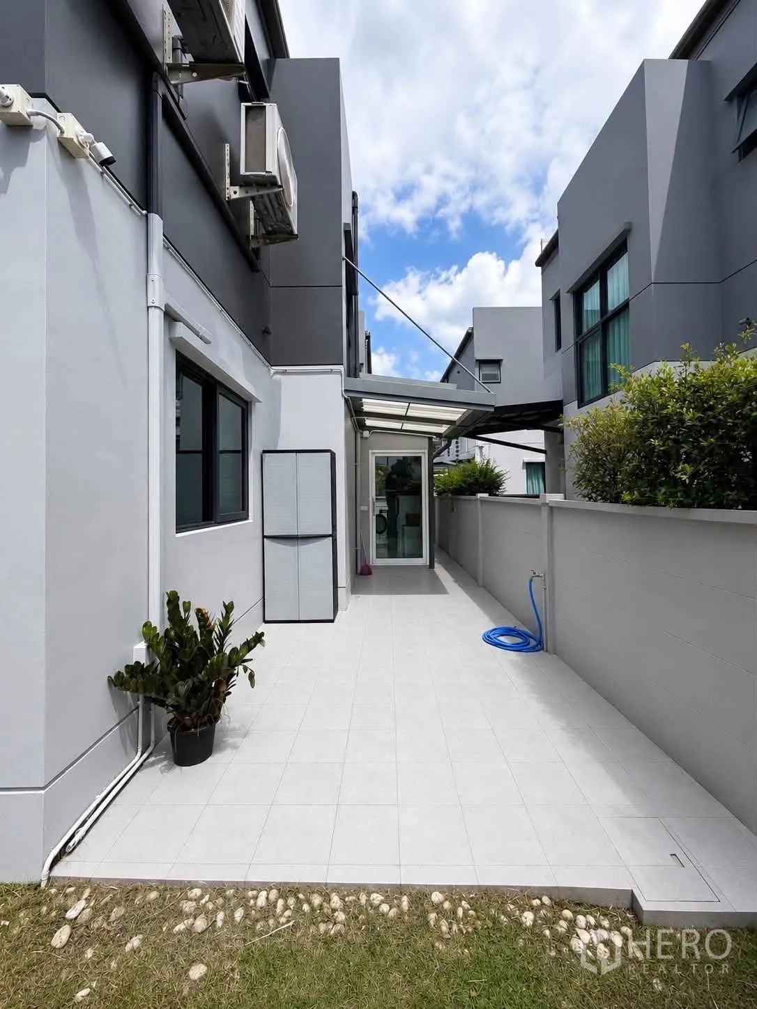独栋房屋 for rent in Bang Phli, Samut Prakan - 侧院铺砖露台，带遮棚、外机与浇水水管。
