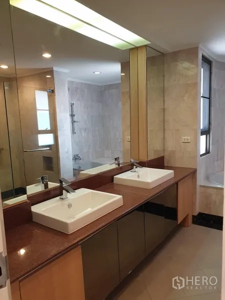 Condominium for rent in Watthana, Bangkok - Primary bathroom featuring double vanity, large mirrors and a tub with shower.