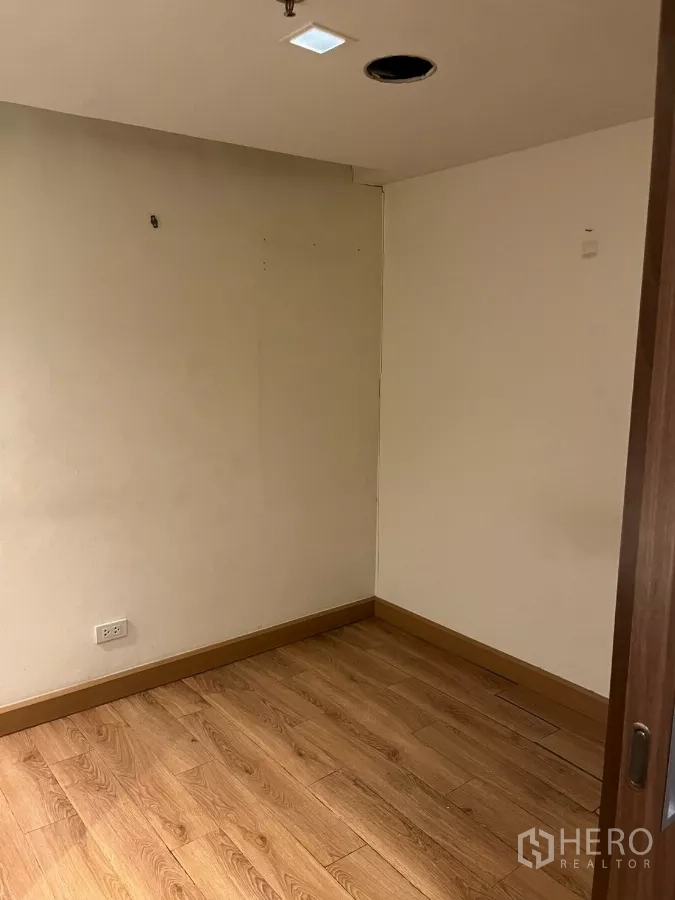 Office Space for rent - Compact private office room with wood flooring and plain walls.