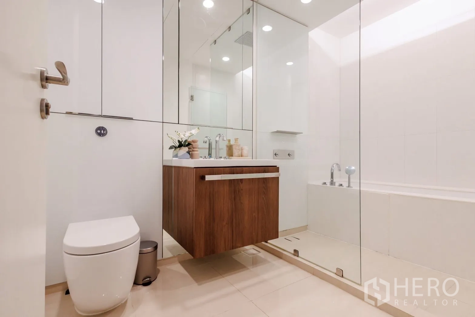คอนโด for rent or sale in Pathum Wan, Bangkok - มุมมองเต็มของห้องน้ำพร้อมตู้อาบน้ำกระจก อ่างอาบน้ำ และเคาน์เตอร์ลอย