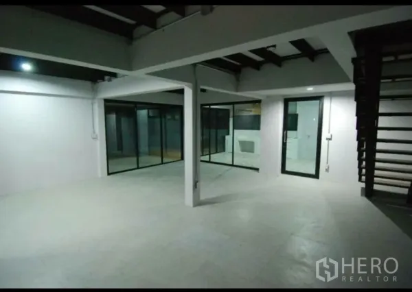 Home Office for rent in Lat Phrao, Bangkok - Spacious open-plan workspace with steel beams and glass walls, ideal for meetings.
