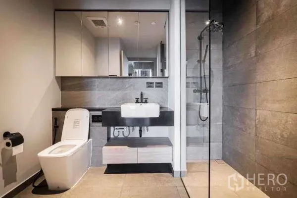 Condominium for rent in Watthana, Bangkok - Sleek bathroom with walk-in rain shower, large mirror cabinets and modern fixtures.