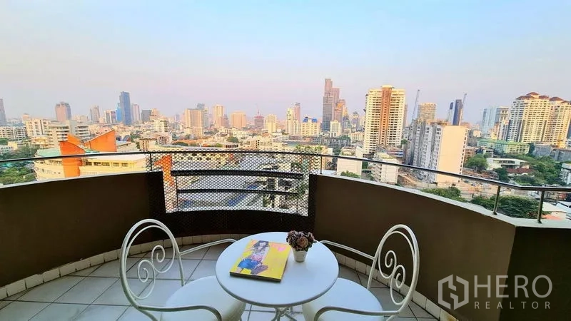 房间 出租在Watthana, Bangkok - 私家阳台，圆形咖啡桌与椅子，享全景城市景观。