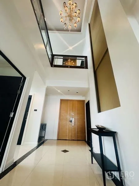 Condominium for rent or sale in Khlong Toei, Bangkok - Grand foyer with mezzanine gallery, chandelier lighting and double wooden entrance doors.