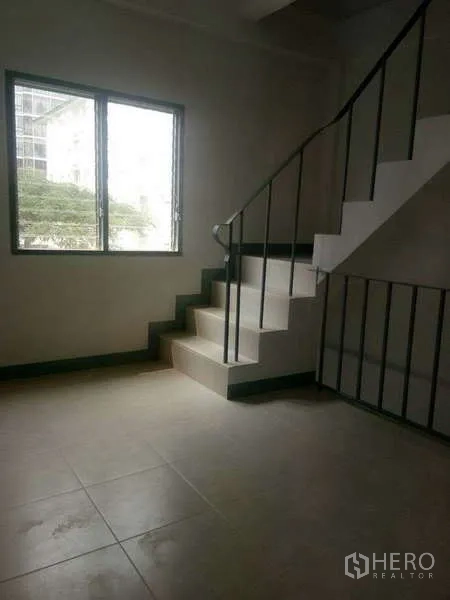 Shophouse for rent in Bang Na, Bangkok - Stair landing with window and railing, ideal for storage or a small workspace.