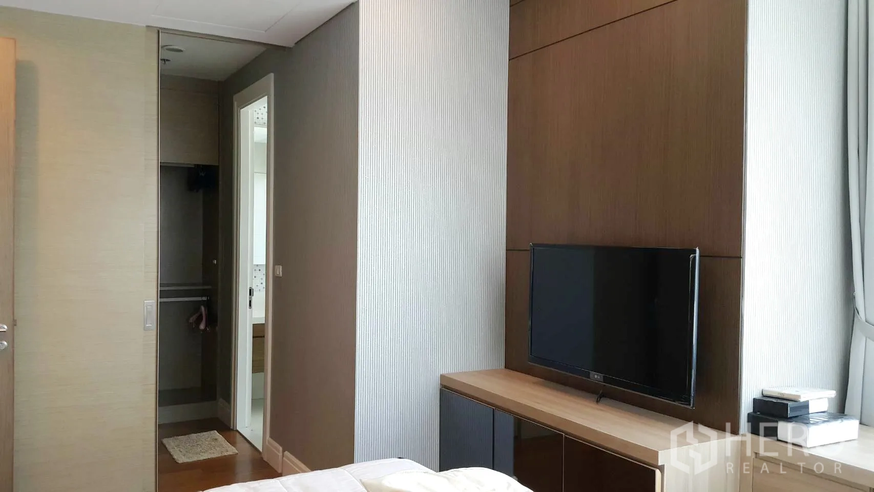 Condominium for rent in Khlong Toei, Bangkok - Cozy bedroom with TV cabinet, built-in wardrobe and a door to the bathroom.