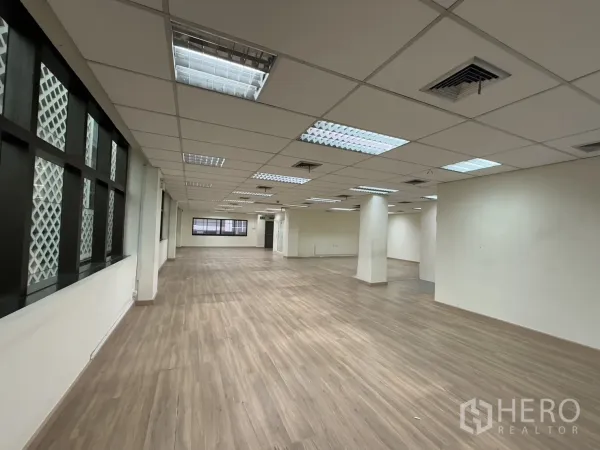 办公空间 出租在Chatuchak, Bangkok - 宽阔办公楼层，带格栅窗饰、网格吊顶与空调风口，连续复合地板。