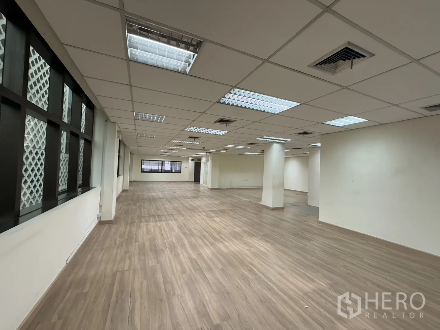 办公空间 出租在Chatuchak, Bangkok - 宽阔办公楼层，带格栅窗饰、网格吊顶与空调风口，连续复合地板。