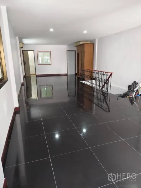Townhouse for sale in Phra Khanong, Bangkok - Large upper-floor family room with black floor tiles and wrought-iron railing.