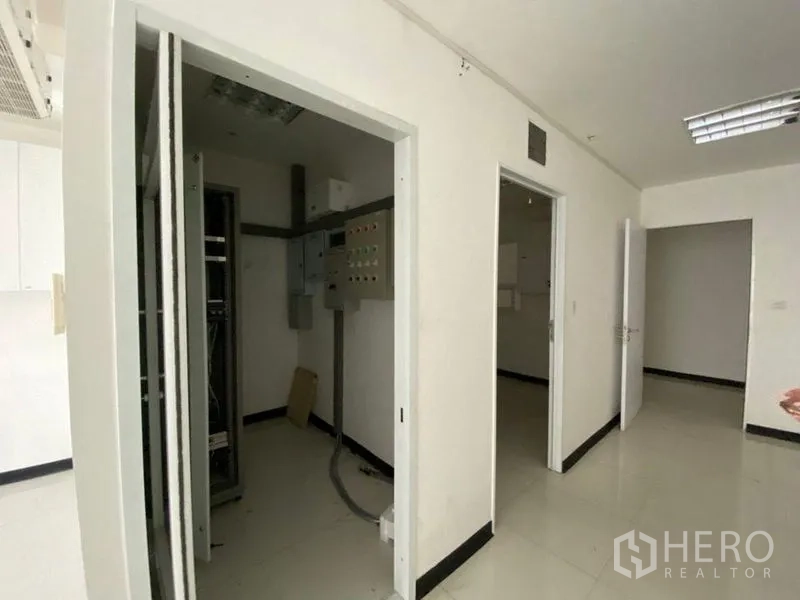 Retail Space for rent - Service corridor showing electrical control panels and server rack room.