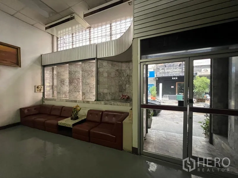 Shophouse for sale - Lobby seating by glass-block feature wall near the front doors.