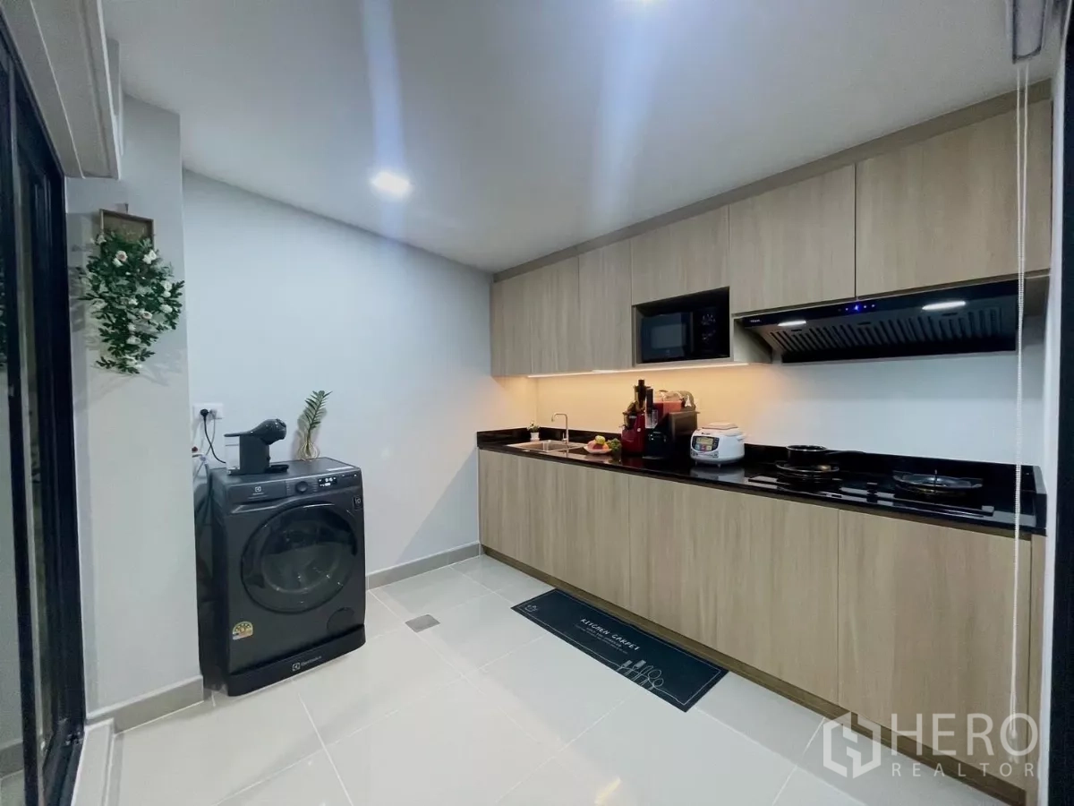 Townhouse for rent in Samut Prakan - Kitchen view with Electrolux washer, appliances and sliding glass door.