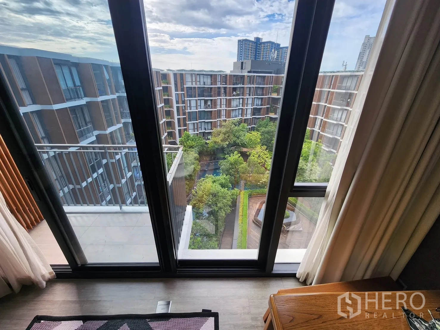 公寓 for rent in Watthana, Bangkok - 推拉门通向阳台，可欣赏园林中庭与周边楼景。