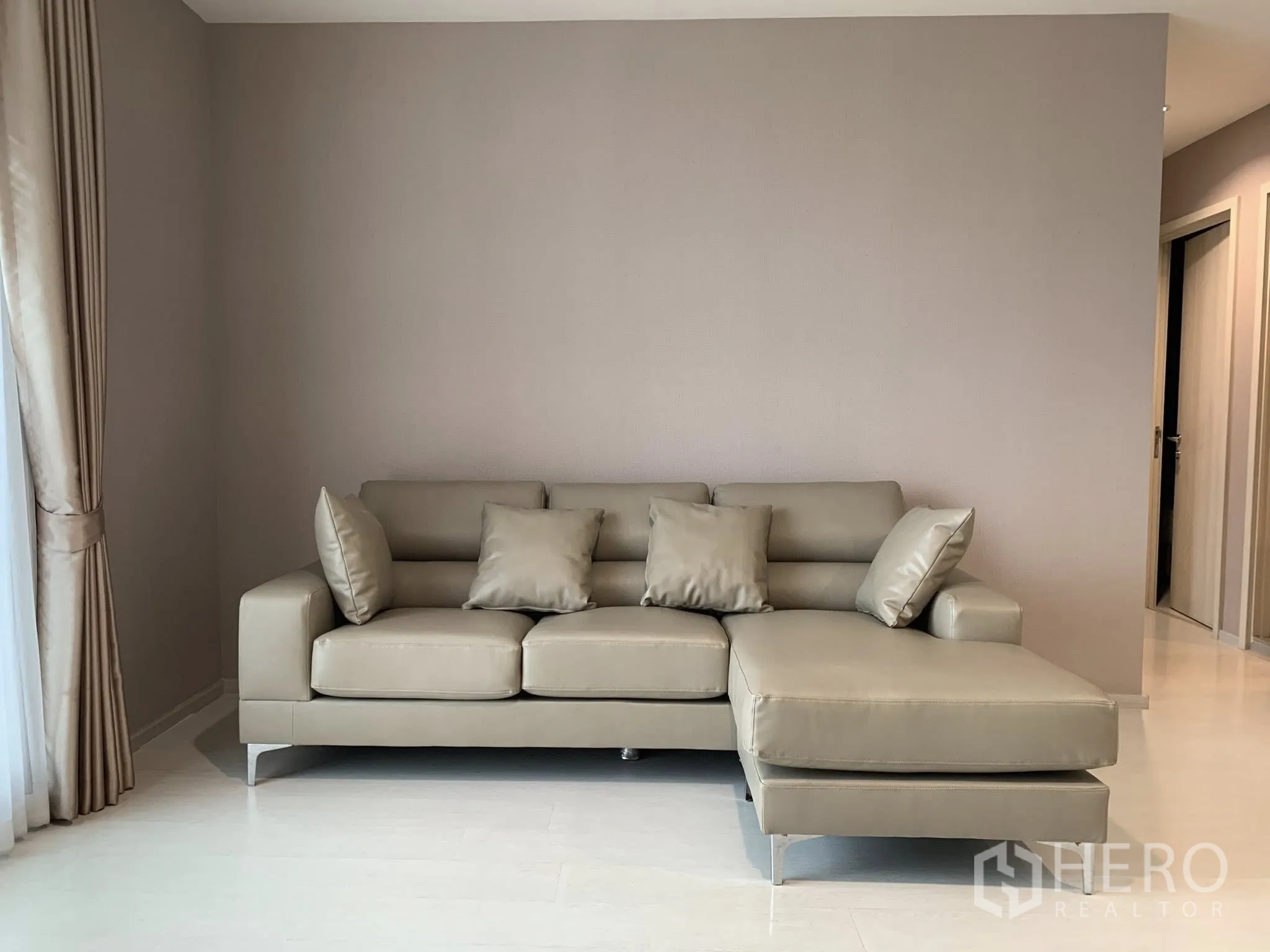 คอนโด for rent in Khlong Toei, Bangkok - ห้องนั่งเล่นมีโซฟาเข้ามุมโทนเทาอ่อน ผนังโทนเรียบ และผ้าม่านสูงจรดเพดาน