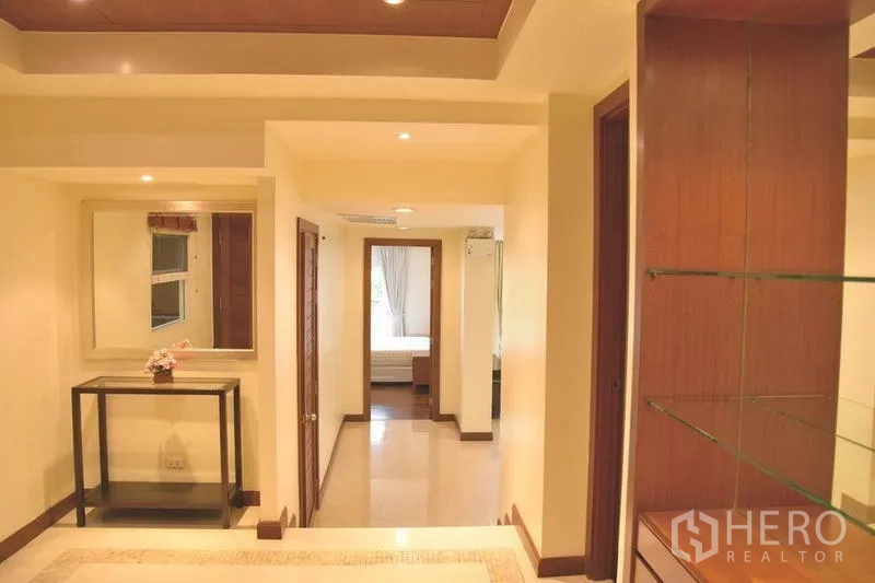 Apartment for rent in Sathon, Bangkok - Entrance hallway with recessed lights and built‑in shelving.