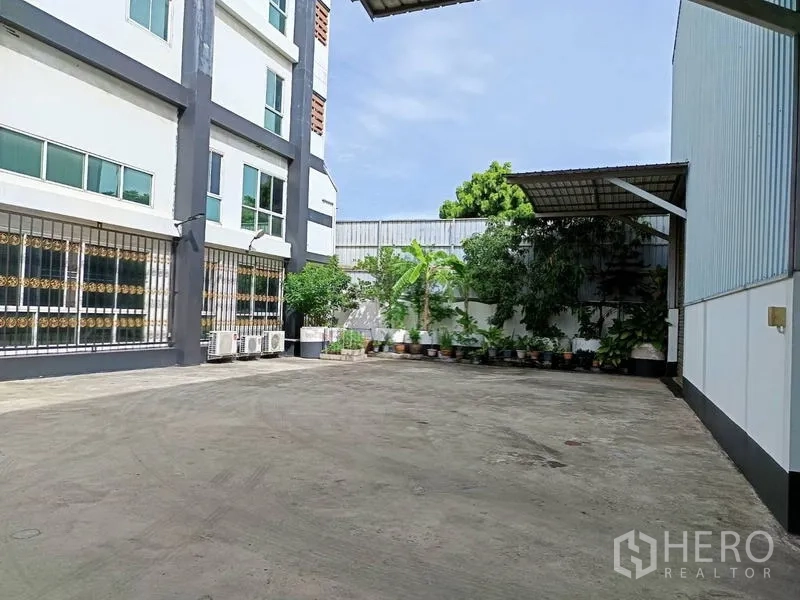 โรงงาน ขายในBan Phaeo, Samut Sakhon - อาคารสำนักงานด้านหน้า หน้าต่างบานใหญ่ เครื่องปรับอากาศ และกระถางต้นไม้ในคอร์ต