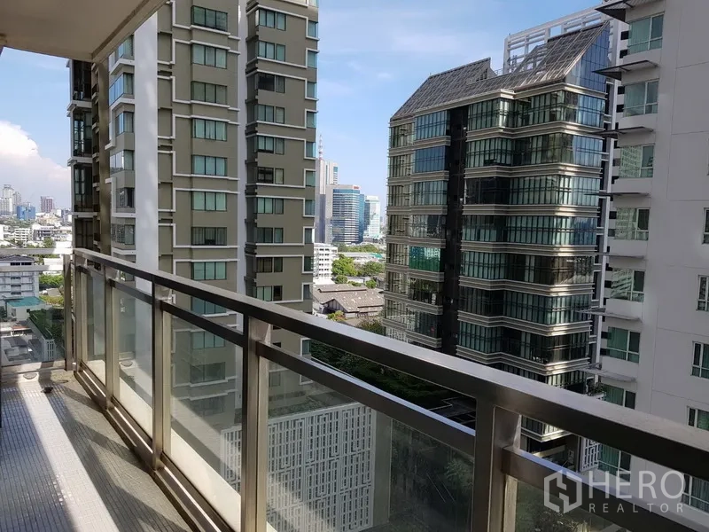 Condominium for rent in Khlong Toei, Bangkok - Private balcony with glass railing overlooking Bangkok high‑rise skyline.