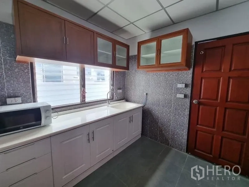 บ้าน ให้เช่าในNonthaburi - ครัวบิวท์อิน เคาน์เตอร์สีขาว อ่างล้างจาน ไมโครเวฟ และตู้แขวน