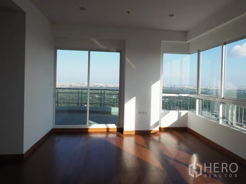 公寓 出租或出售在Yan Nawa, Bangkok - 带阳台门的房间，转角窗提供全景城市视野。