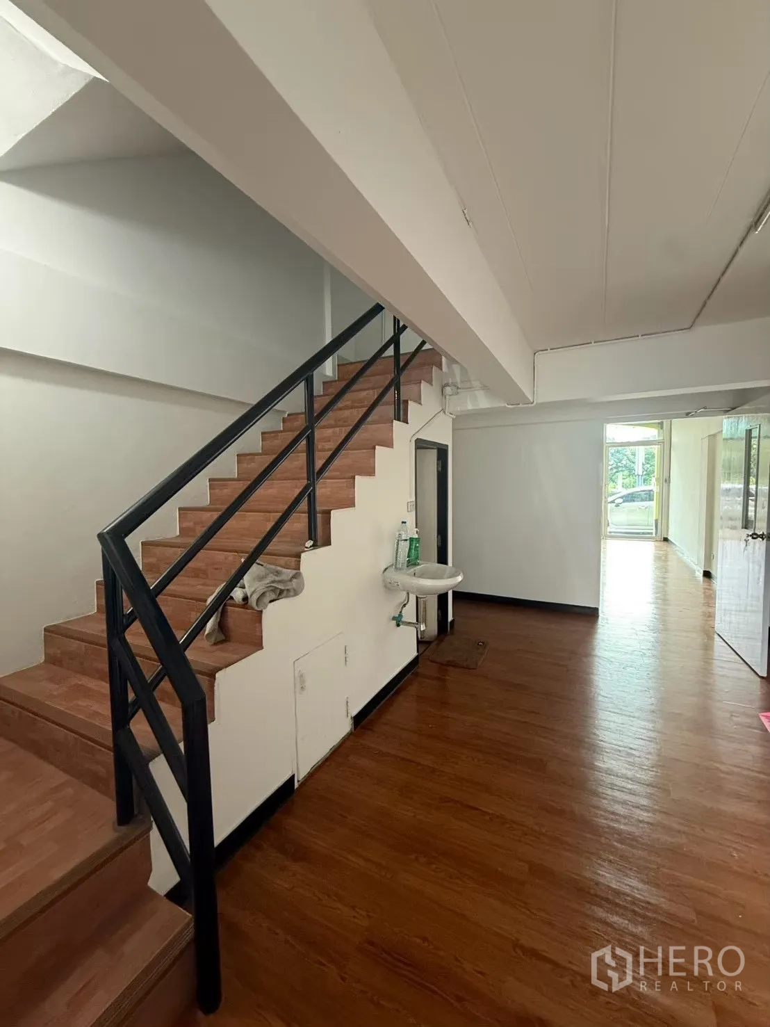 Shophouse for rent in Pak Kret, Nonthaburi - Staircase with wood steps and a small wall-mounted sink.