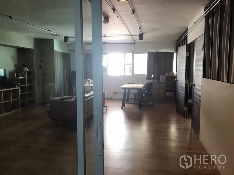 办公空间 出租在Phaya Thai, Bangkok - 开放式办公室，木地板、玻璃隔断、靠窗书桌与裸露管线。