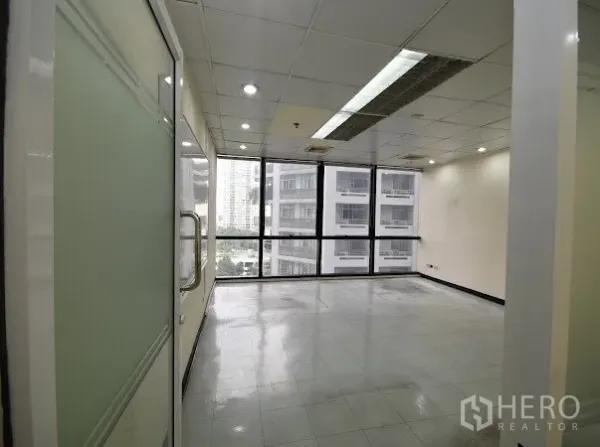 办公空间 出租在Watthana, Bangkok - 采光充足的办公室，玻璃门与全景窗，面向邻近大楼。