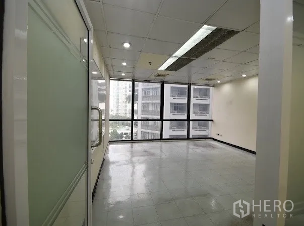 办公空间 出租在Watthana, Bangkok - 采光充足的办公室，玻璃门与全景窗，面向邻近大楼。