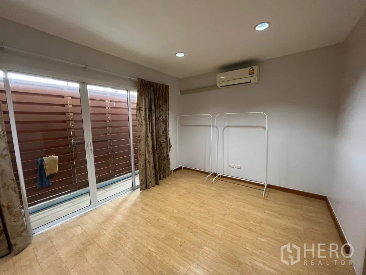 Townhouse for rent in Bang Kho Laem, Bangkok - Multi-purpose room with sliding doors to terrace, air-conditioning, and wood-look floor.