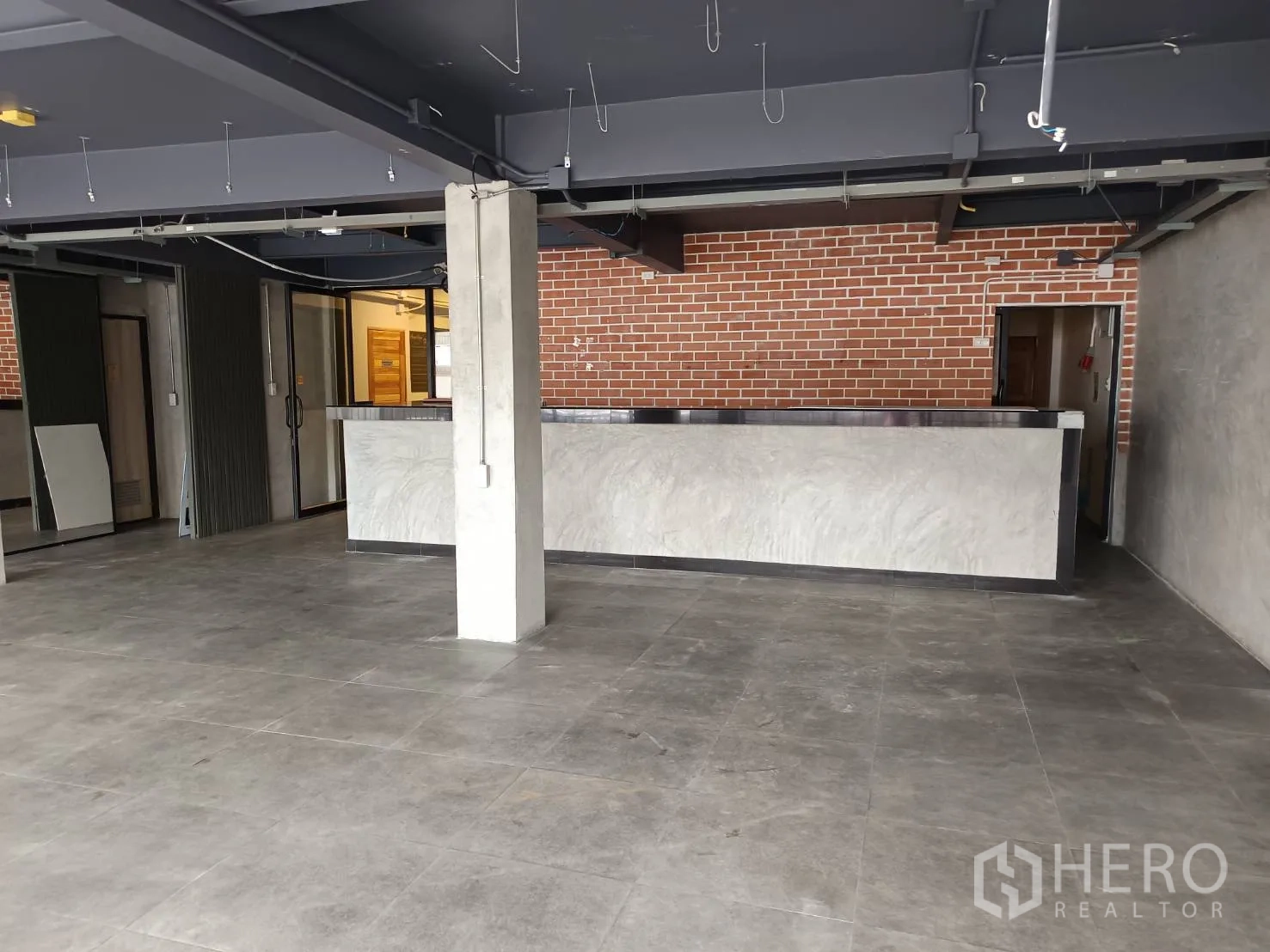 Retail Space for rent in Watthana, Bangkok - Open-plan retail interior with polished concrete floor, long counter and brick feature wall.