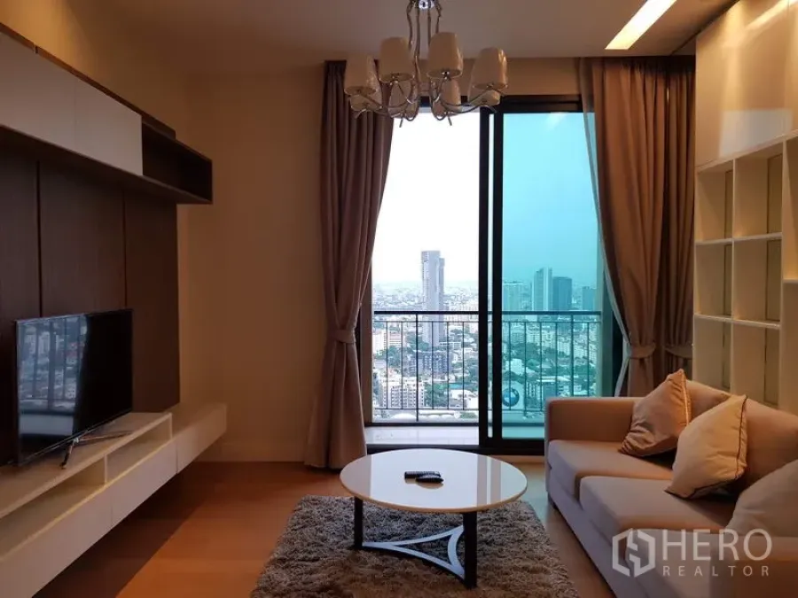 公寓 出租在Chatuchak, Bangkok - 客厅配沙发和吊灯，推门连通阳台眺望曼谷城景。
